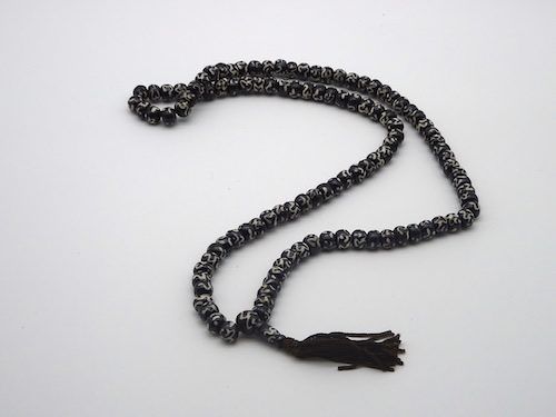 Mala budista pintado de negro con el mantra OM